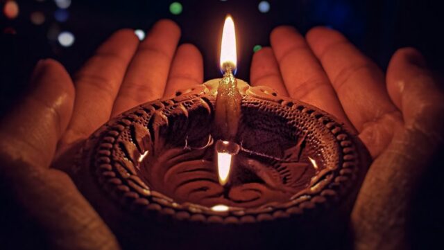 lighted candle on brown round holder
