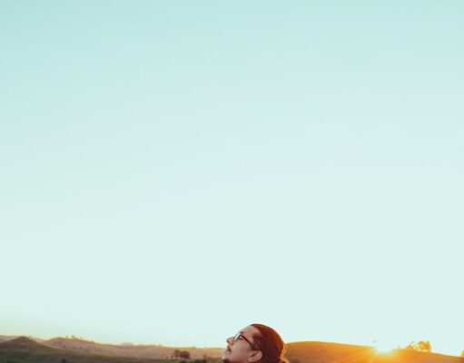 Mental Peace or Financial Success man in white shirt sitting on green grass field during sunset