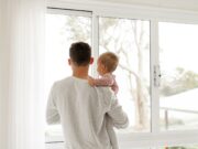 Father’s Day boy in gray sweater standing beside window during daytime