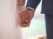 Don’t Marry man in black suit jacket holding hands with woman in white dress